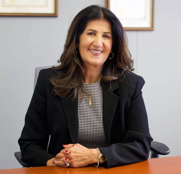 Photo of houston immigration attorney nisreen mousa sitting at a desk